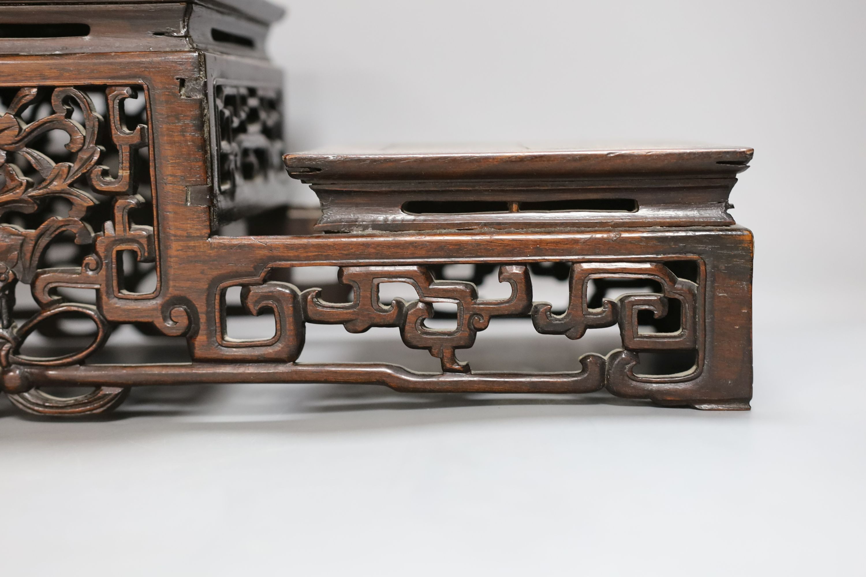 A Chinese carved hardwood 3 tier stand, late Qing, together with other similar stands. Largest 49cm
